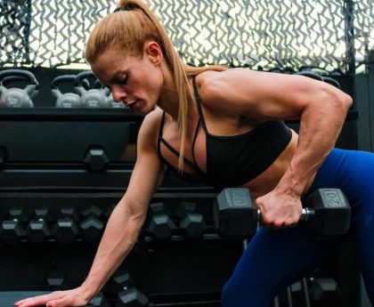 A fit woman lifting weights in a gym setting illustrating determination and strength.