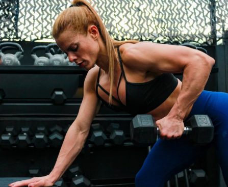 A fit woman lifting weights in a gym setting illustrating determination and strength.
